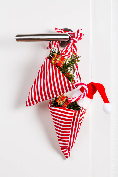 Kis karácsonyi táska ággal és cukornád lóg ajtókilincs - Fotó, kép