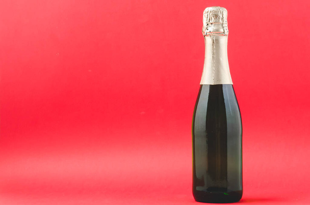 Champagne glasses and bottle on red background, space for text.  - Valokuva, kuva