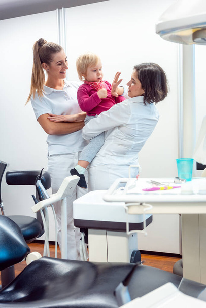 Dentist and her assistant with child in the office - Foto, imagen