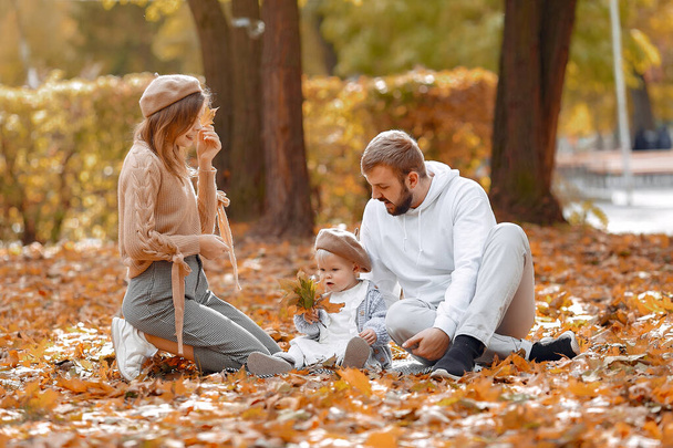 Family with little daughter in a autumn park - Фото, изображение