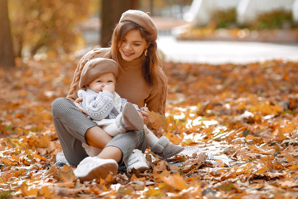秋の公園でかわいいとスタイリッシュな家族 - 写真・画像
