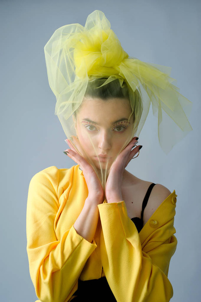 Glamour γυναίκα μόδας με art makeup σέξι σύντομο κομψό κίτρινο φθορά και πέπλο στο κεφάλι της, συναισθήματα - Φωτογραφία, εικόνα