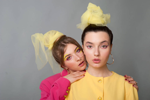 Deux filles dans des vêtements colorés vives debout, regardant caméra fond isolé
. - Photo, image
