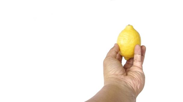 Image of a man's hand holding a lemon isolated on white background - Fotó, kép