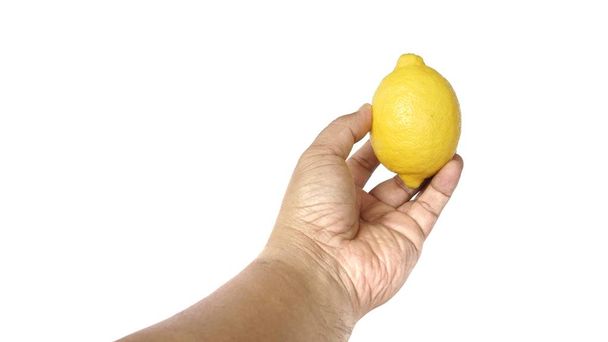 Imagem da mão de um homem segurando um limão isolado no fundo branco
 - Foto, Imagem