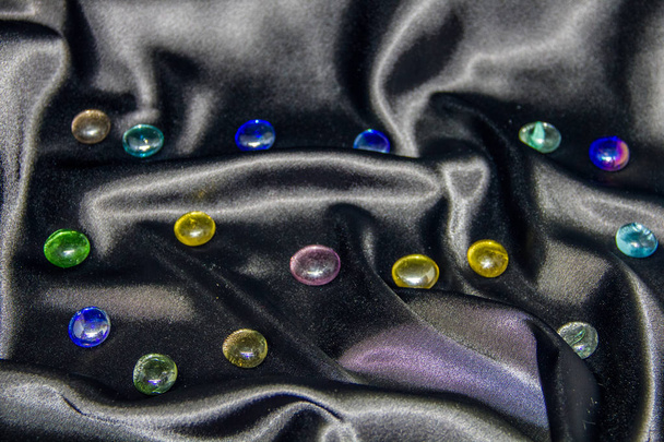 colored glass stones on a black background. looks like a starry night sky - Foto, Imagem