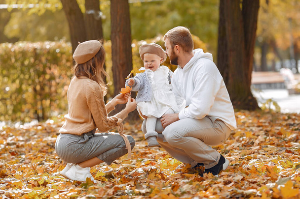 Family with little daughter in a autumn park - Foto, imagen