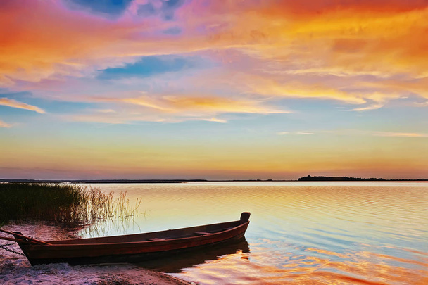 Sunset on the lake, fishing boat on the shore. - Foto, Bild