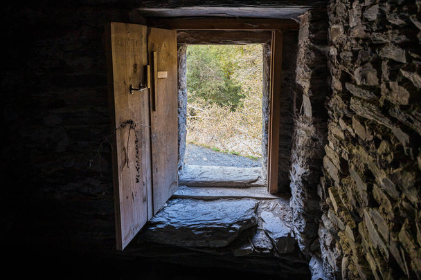 La puerta de los restos de un solitario de pie en el río al pie de la torre de vigilancia de las montañas Koshki llamada la Torre del Amor en Svaneti en la parte montañosa de Georgi
 - Foto, Imagen