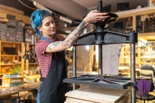 Selbstbewusste junge Handwerkerin in ihrer Werkstatt - Foto, Bild