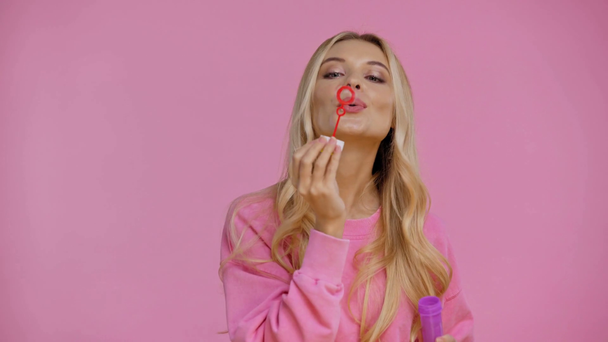 mulher sorrindo soprando bolhas de sabão isolado em rosa
 - Filmagem, Vídeo