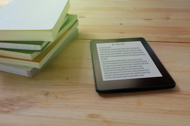 Leitor de e-book e pilha de livros em mesa de madeira
 - Foto, Imagem