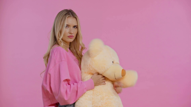 trieste vrouw houden teddy beer geïsoleerd op roze - Video