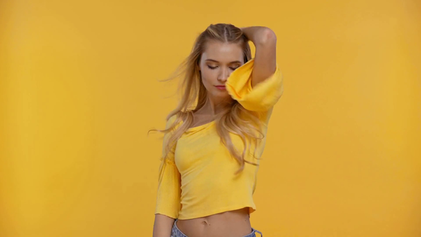 smiling woman dancing isolated in yellow - Materiał filmowy, wideo