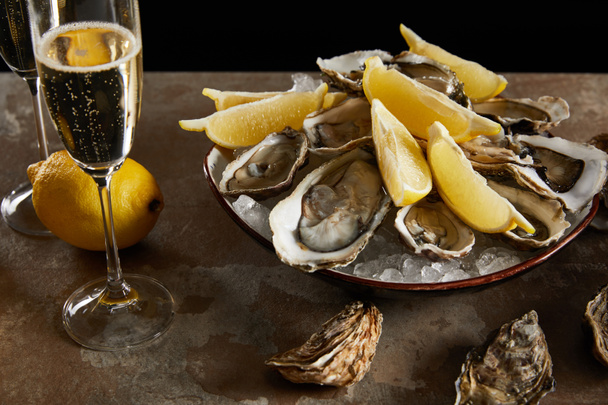 champagne glasses with sparkling wine near oysters and fresh lemons in bowl  - Photo, Image