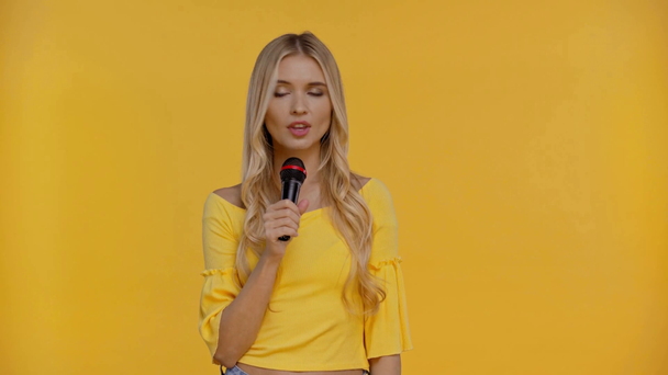 nő beszél és ujjal mutogat izolált sárga - Felvétel, videó