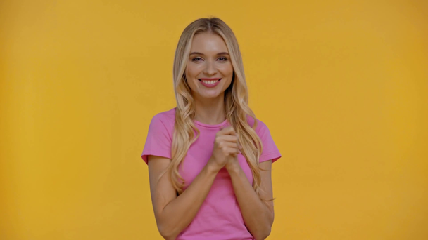 dreamy and smiling woman with crossed arms isolated in yellow - Imágenes, Vídeo
