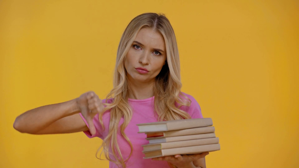 mujer sosteniendo libros y mostrando aversión aislada en amarillo
 - Imágenes, Vídeo