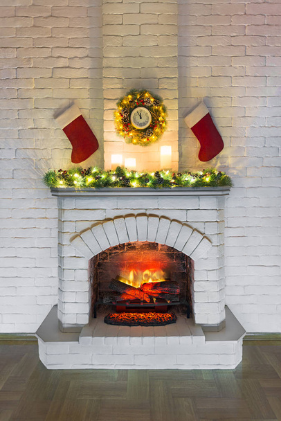 Chimenea blanca con fuego decorado para Navidad con velas
,  - Foto, imagen