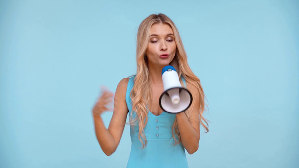 Irritierte Frau hält Lautsprecher isoliert auf blauem Grund - Filmmaterial, Video