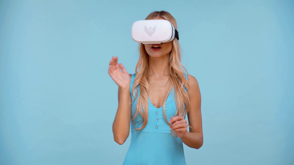 γυναίκα με ακουστικά εικονικής πραγματικότητας απομονωμένα σε μπλε - Πλάνα, βίντεο