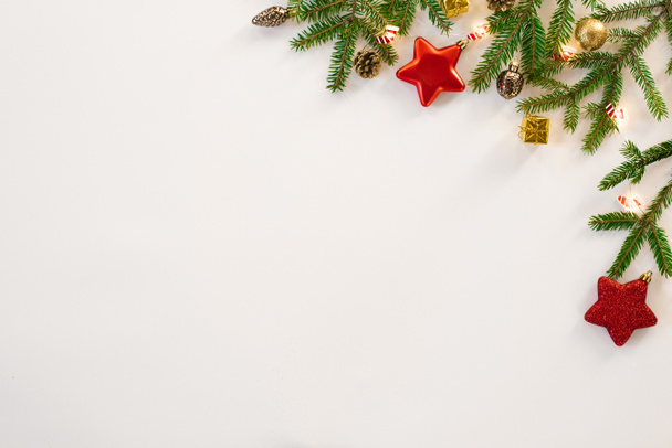 Karácsonyi kompozíció, határ, keret. Karácsonyi dekorációk, fenyőágak és tobozok, csillagok és hópelyhek fehér alapon, felülnézetből. Lapos pozíció, másolás. Üdvözlőlap - Fotó, kép
