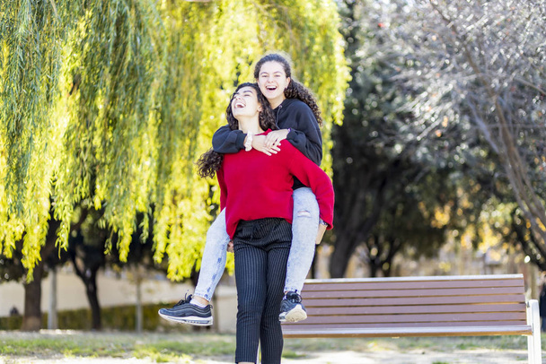 Due adolescenti ridono e pagano su un parco
 - Foto, immagini