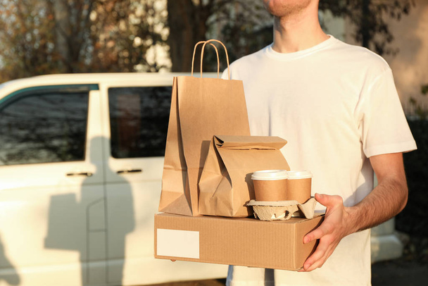 estocástico ourier sostiene caja en blanco, tazas de café y paquetes de papel contra
 - Foto, Imagen
