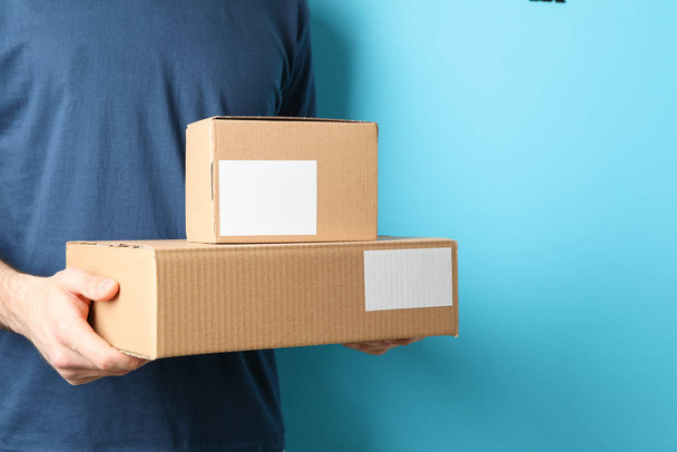 Uomo di consegna tenere scatole vuote sullo sfondo blu, spazio per
 - Foto, immagini