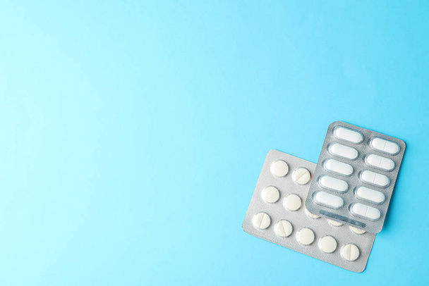 Pillen in blisterverpakkingen op blauwe achtergrond, ruimte voor tekst - Foto, afbeelding