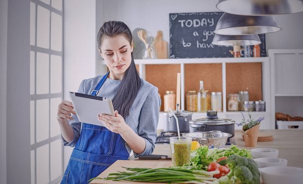 Szczęśliwa kobieta patrząc przepis tablet kuchnia czytanie gotowanie - Zdjęcie, obraz