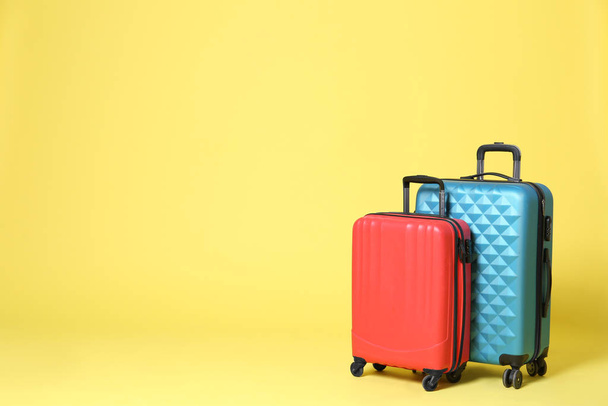 Stylish suitcases on yellow background. Space for text - Photo, Image