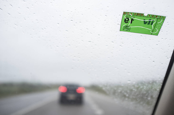 Járművizsgálati matrica a szélvédőn egy esős napon - Fotó, kép