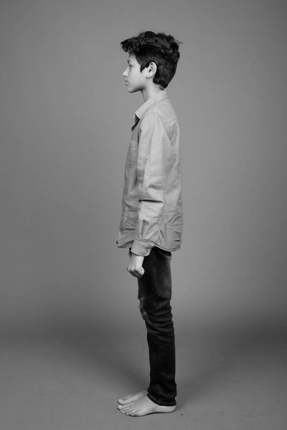 Joven chico indio usando ropa casual inteligente contra fondo gris
 - Foto, Imagen