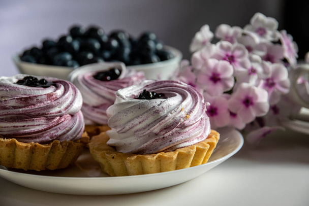 Torta doce com merengue e geléia de huckleberry e buquê de p
 - Foto, Imagem
