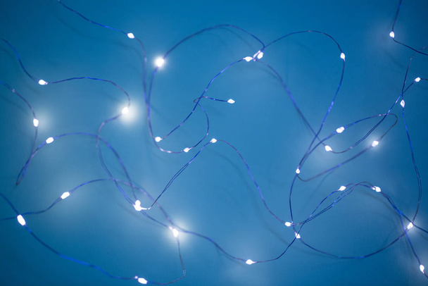 Christmas lights on dark blue background with copy space. Decorative garland - Foto, Imagen