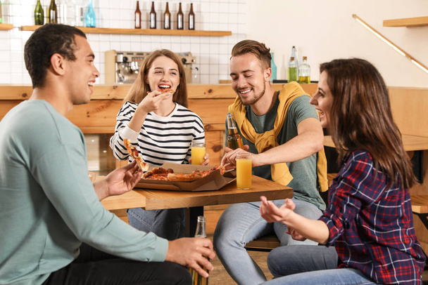 Group of friends having fun party with delicious pizza in cafe - Фото, зображення