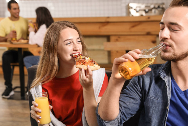 Young couple eating delicious pizza in cafe - Foto, Imagem