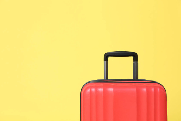 Stylish red suitcase on yellow background. Space for text - Zdjęcie, obraz