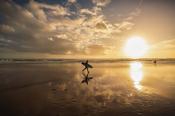 Surfer na plaży o zachodzie słońca, Caravelos Beach, Portugalia - Zdjęcie, obraz