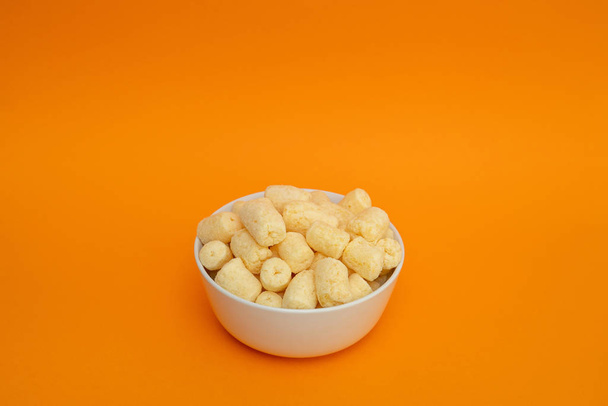 Crunchy sweet corn sticks with powdered sugar in white bowl - Фото, изображение