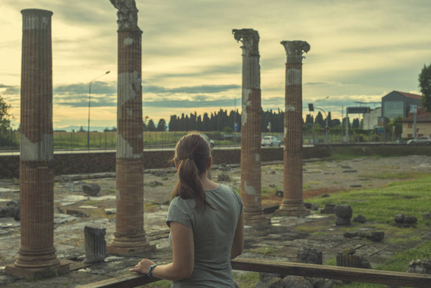 Back view of young woman standing in front of antique roman, gre - Photo, Image