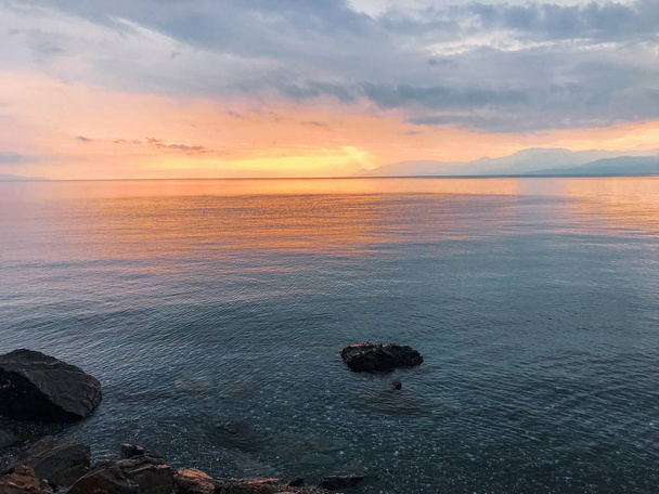 Πολύχρωμος ουρανός και ήρεμη θάλασσα στο ηλιοβασίλεμα  - Φωτογραφία, εικόνα