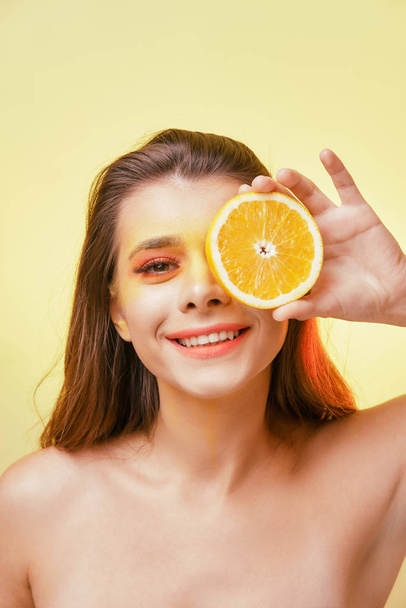 Portrait of a smiling girl with bright makeup on a yellow background.  - Φωτογραφία, εικόνα