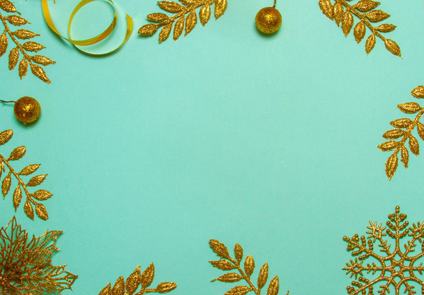 Christmas and New Year green background with gold leaves. Festive concept, place for text. Shot from above. Beautiful flat lay. - Photo, Image