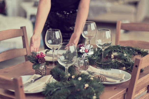 女は客を待ってテーブルを用意するお祝いのテーブルやクリスマスディナーの準備. - 写真・画像