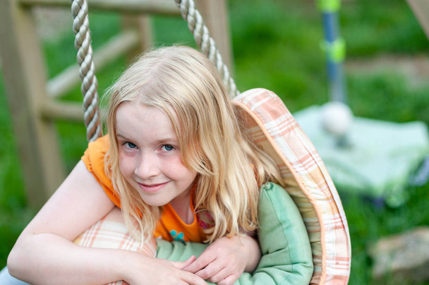 Headshot de menina loira muito jovem fazendo contato visual e sorrindo
 - Foto, Imagem