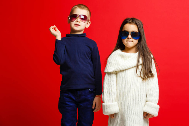 Двоє щасливих смішних дітей, що стоять разом і приймають, ізольовані на червоному
  - Фото, зображення