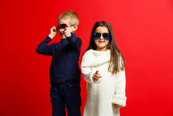 Двоє щасливих смішних дітей, що стоять разом і приймають, ізольовані на червоному
  - Фото, зображення