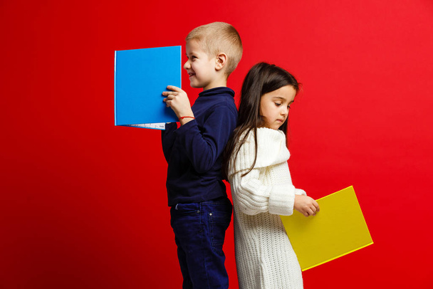 Little children with books isolated on red  - Φωτογραφία, εικόνα